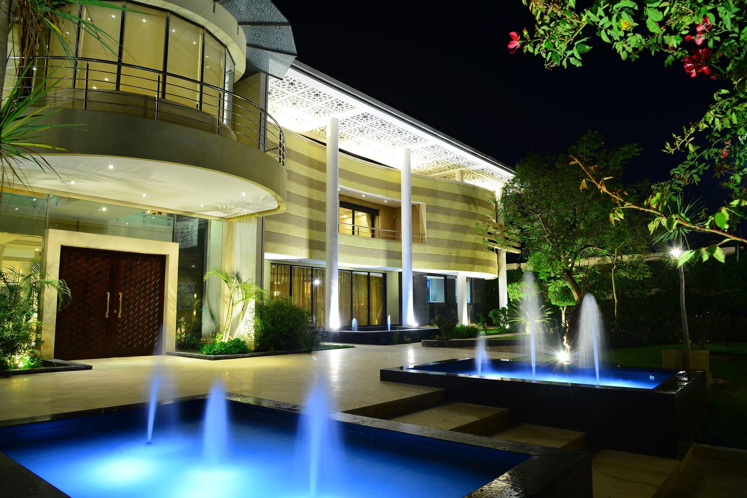 Fountains lit blue in front of the entrance at night
